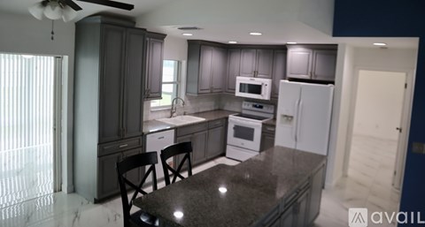 A kitchen with a table and chairs in front of a refrigerator.