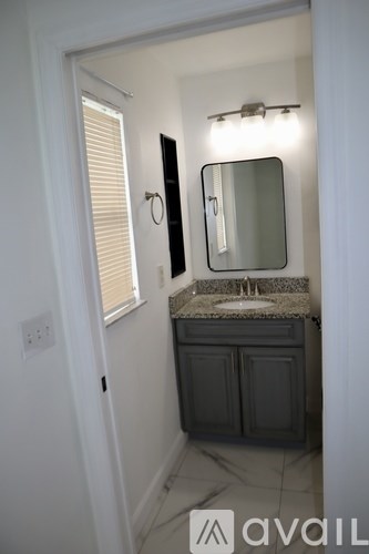 A bathroom with a sink, mirror, and cabinets.