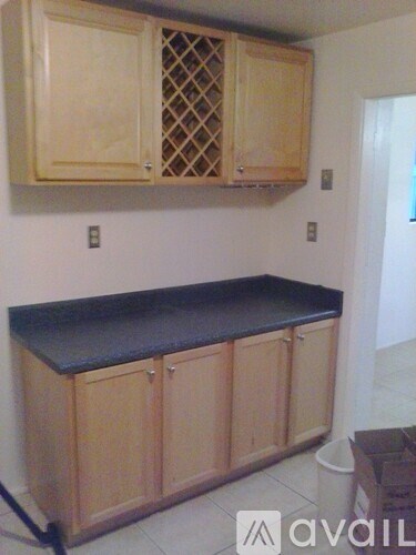 A kitchen with wooden cabinets and a black countertop.