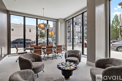 A living room with grey chairs and a coffee table with a bowl of candy on it.