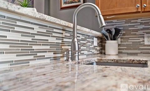 A kitchen counter with a marble top and a modern faucet.
