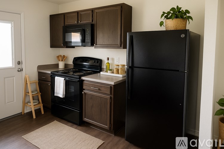 A black refrigerator stands next to a black stove in a kitchen.