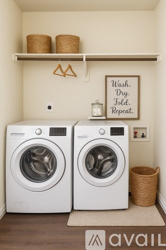 Two white front loading washing machines in a laundry room.