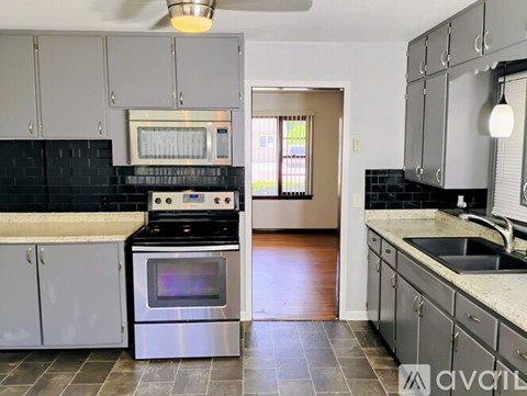 A modern kitchen with a stove top oven and microwave.