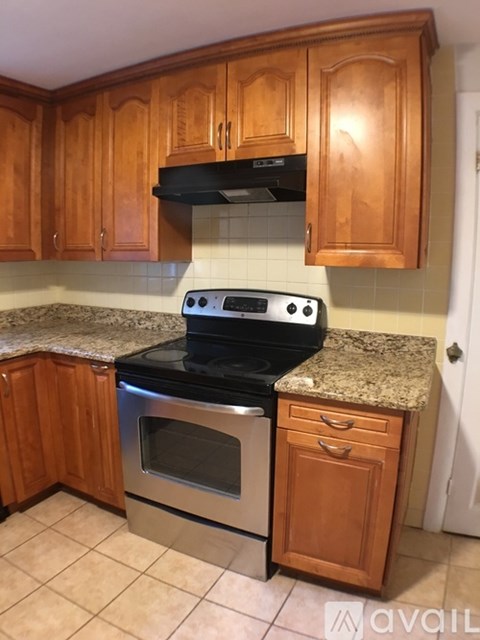 A kitchen with wooden cabinets and a granite countertop.