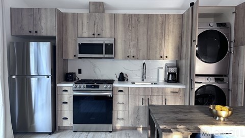 A modern kitchen with wooden cabinets and stainless steel appliances.