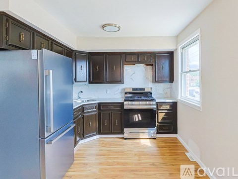 A kitchen with a blue refrigerator and wooden floors.