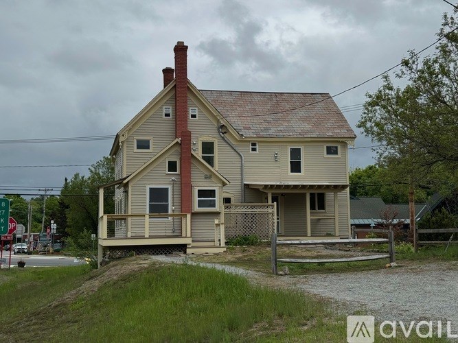 A house with a red chimney is situated on a grassy area.