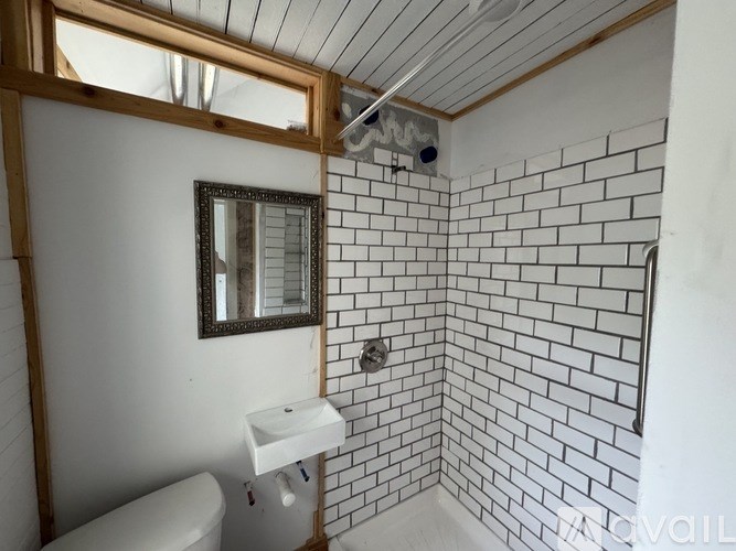 A bathroom with a white toilet, a sink, and a mirror.