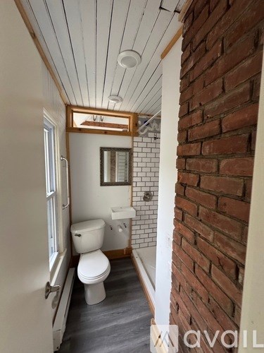 A bathroom with a toilet, sink, and mirror.