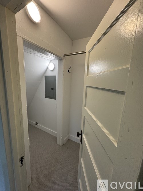 A hallway with a door on the right and a light on the ceiling.