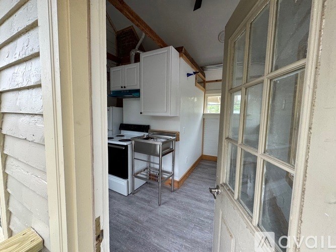 A kitchen with white cabinets and a stove top oven.