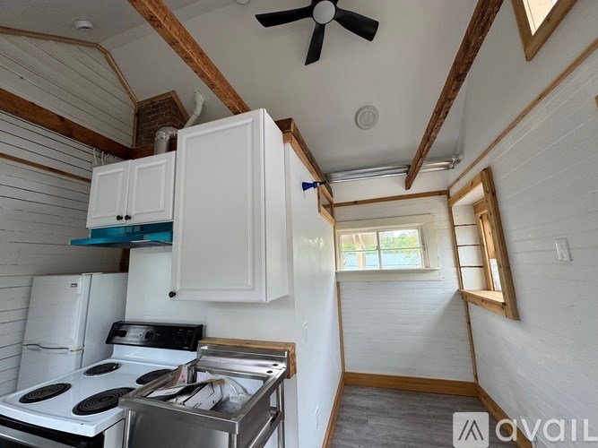 A small kitchen with a stove and a fan.