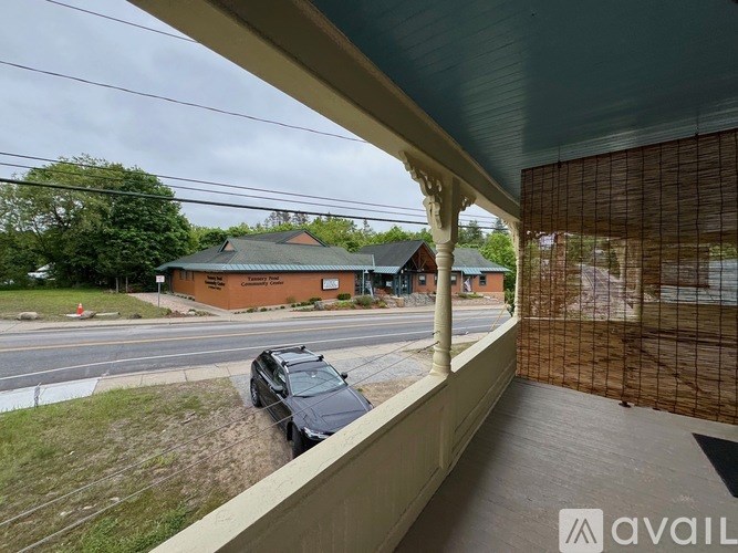 A car is parked on the side of a road next to a building.
