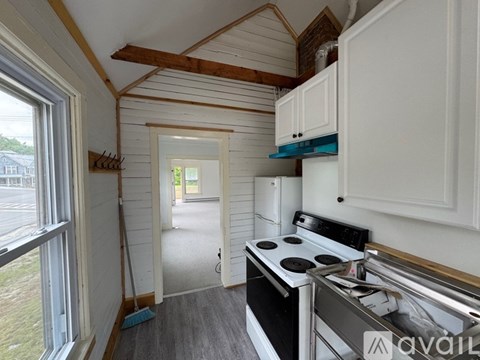 A kitchen with a stove and cabinets is available for rent.