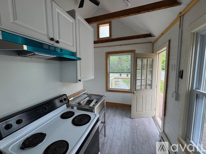 A kitchen with a stove top oven and a window.