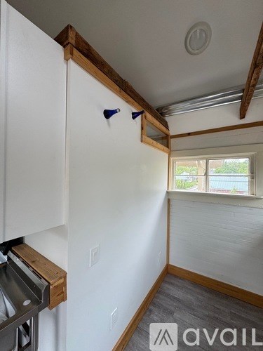 A kitchen with white cabinets and a window.