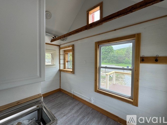 A room with a window overlooking a deck.