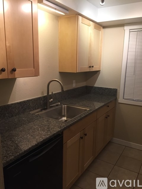 A kitchen with wooden cabinets and a granite countertop.