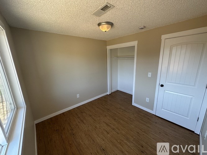 A room with wooden flooring and a white door.