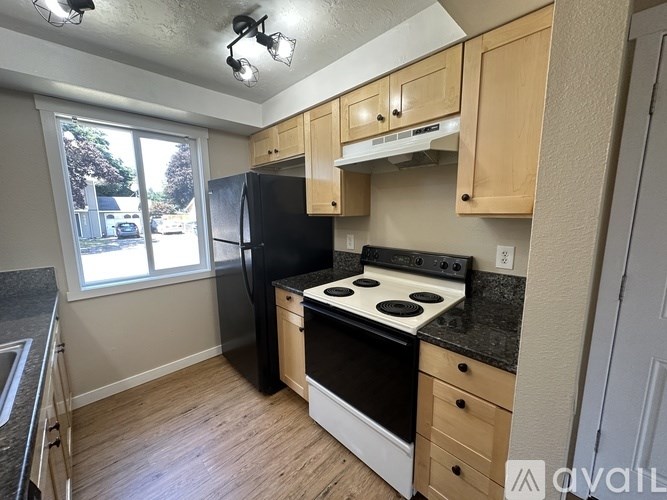 A room with wooden flooring and a window with blinds.