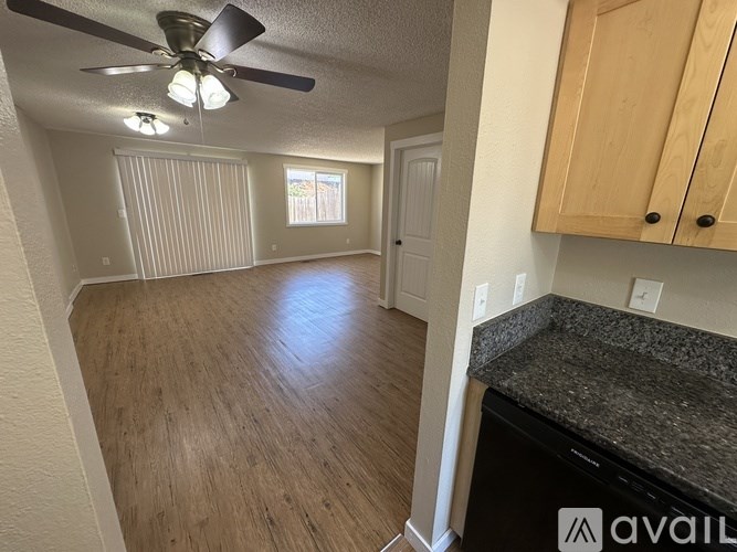 A room with a ceiling fan and wooden flooring.
