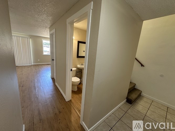 A hallway with a toilet and a mirror.