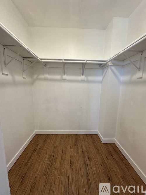 A room with a white wall and a wooden floor.