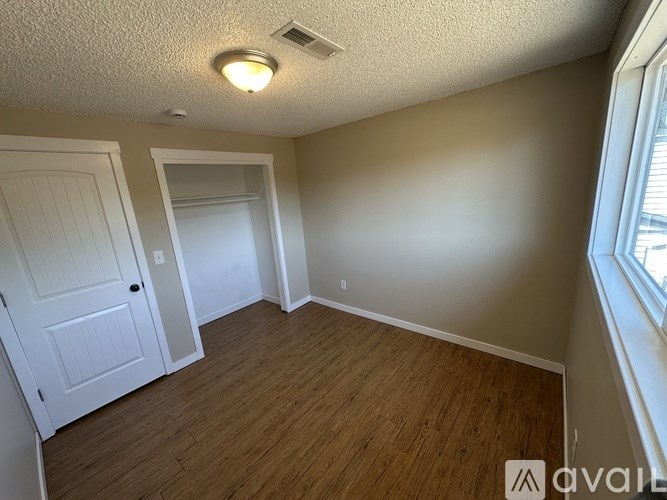 A room with a white door and a window with a view of the outside.