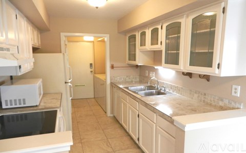 A kitchen with white cabinets and a sink.