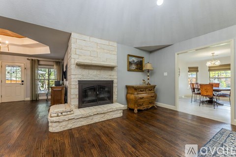A living room with a fireplace and wooden floors.