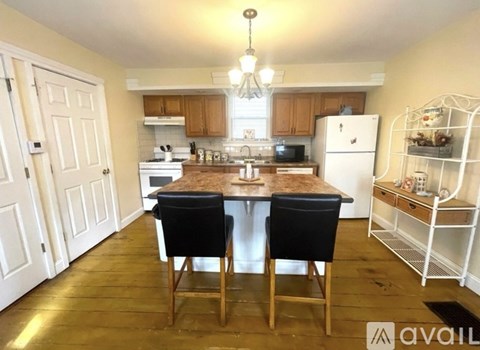 A kitchen with a table and chairs in the middle of it.