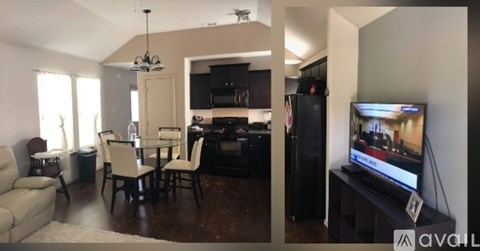 A living room with a television and a kitchen area in the background.