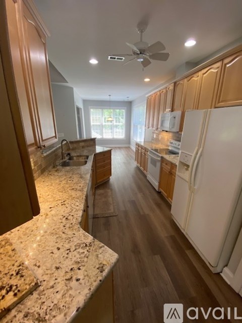 A kitchen with wooden cabinets and a marble countertop.
