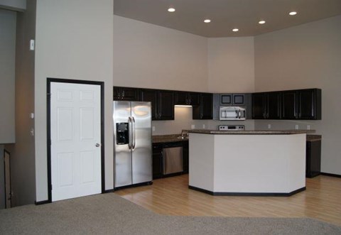 an empty kitchen with a refrigerator and a sink