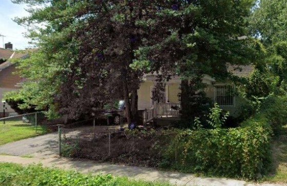 A house is surrounded by greenery and trees.