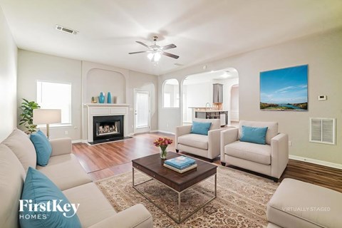 A living room with a fireplace and a painting on the wall.