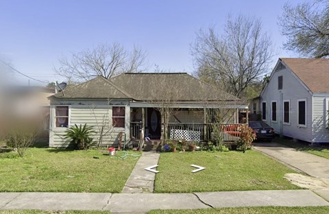 A house with a grey roof and a white fence.
