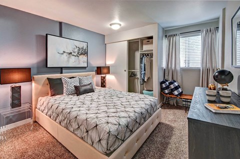 A bedroom with a large bed and a painting on the wall.