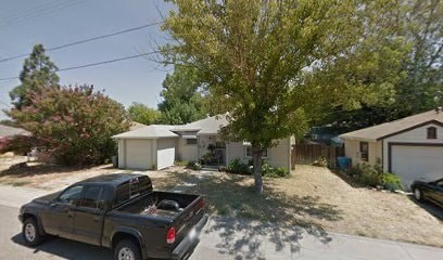 A truck is parked in a driveway in front of a house.