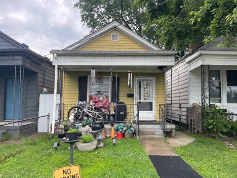 A yellow house with a "No Parking" sign in front of it.