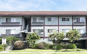 A white building with a red roof and balconies.