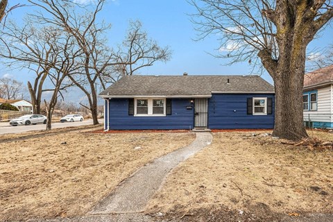 A blue house with a grey roof and a grey door.