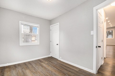 A room with a white door and a window with a white frame.