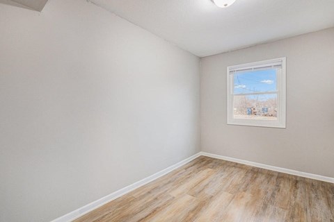 A room with a window and a picture on the wall.