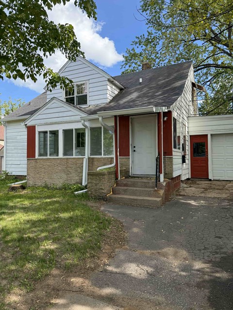 A house with a red door and a white garage door.