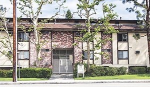 A building with a red brick wall and a glass door.
