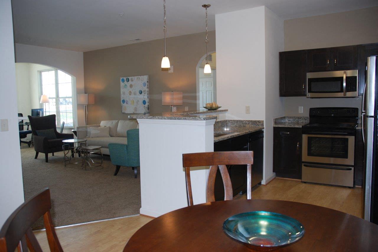 A kitchen with a table and chairs in the foreground.