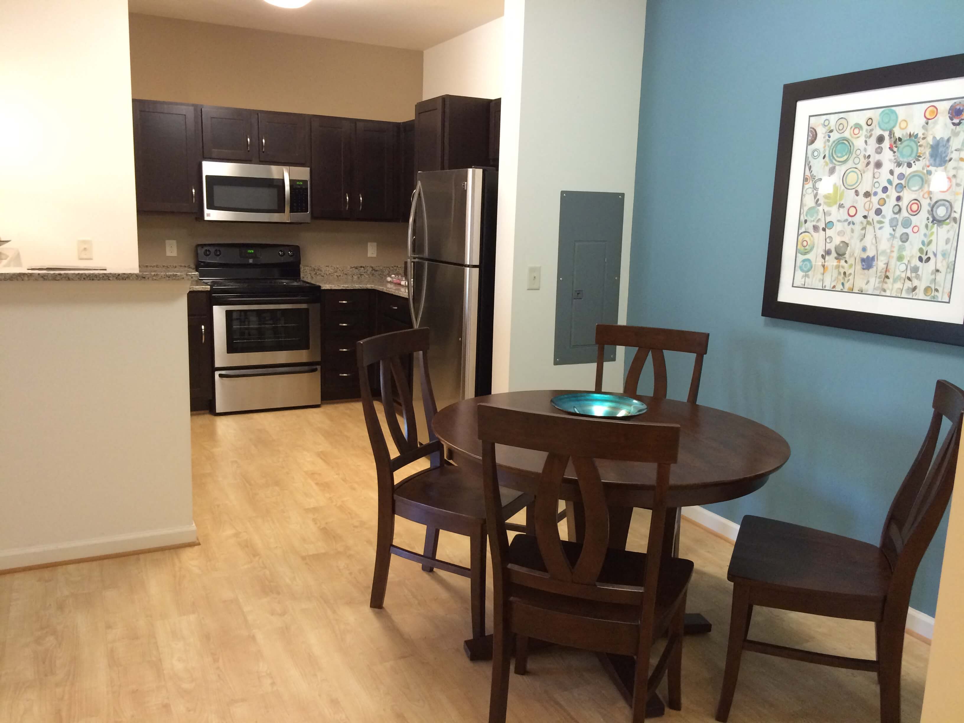 A kitchen with a table and chairs.
