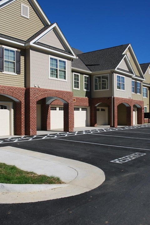 an empty parking lot in front of a row of houses